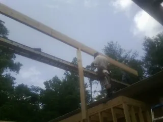 Carpenter setting a ridge beam over a new addition frame — Ice Dam Removal by Roofing Brothers in Lookout Mountain