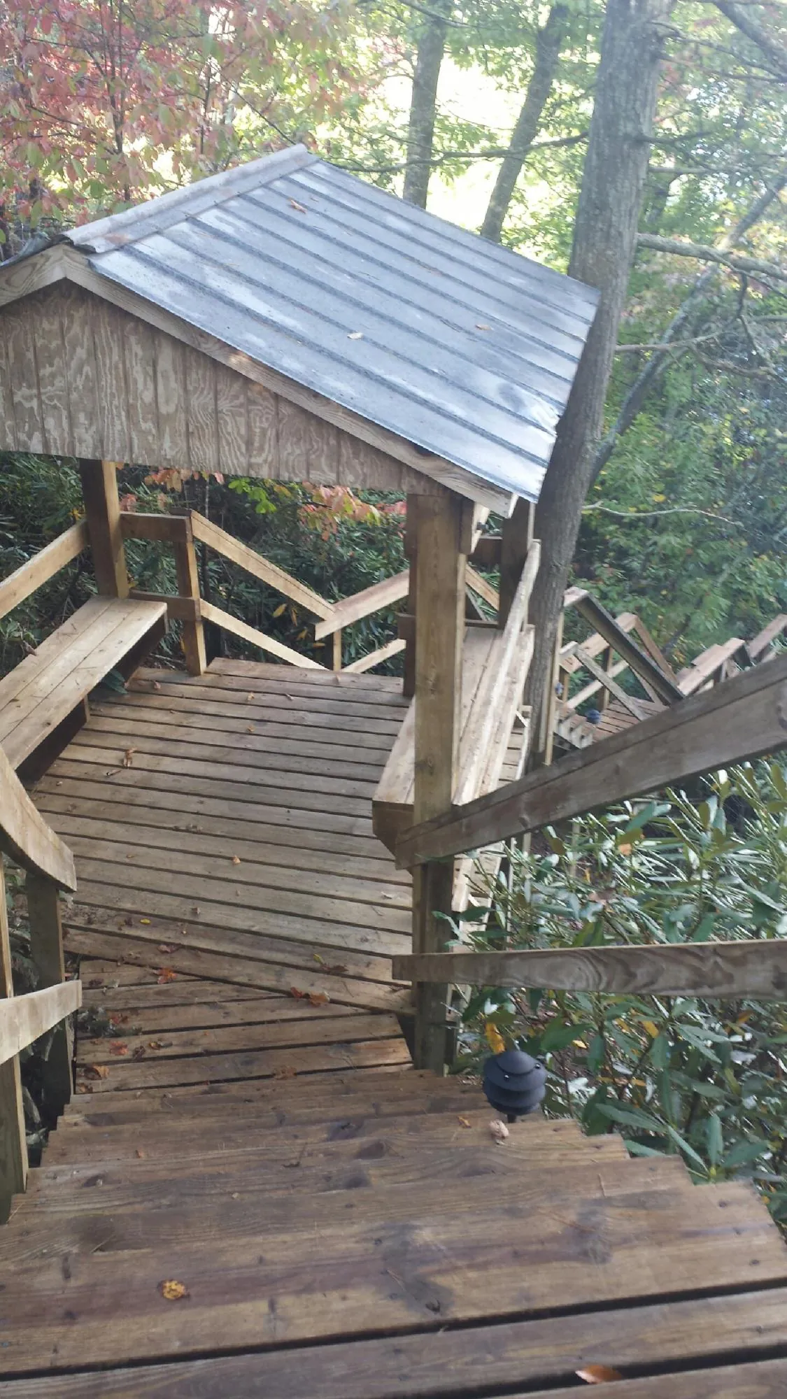 Metal roofed shelter over wooden steps on a wooded walkway — Skylight Repair & Installation work by our crew in Lookout Mountain